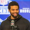 FootballR - NFL Draft Reihenfolge 2024 - Diese Beschreibung wurde automatisch generiert. Ein Mann mit Bart, Caleb Williams, lächelt während des NFL Combine in ein Mikrofon.