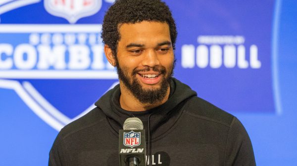 FootballR - NFL Draft Reihenfolge 2024 - Diese Beschreibung wurde automatisch generiert. Ein Mann mit Bart, Caleb Williams, lächelt während des NFL Combine in ein Mikrofon.